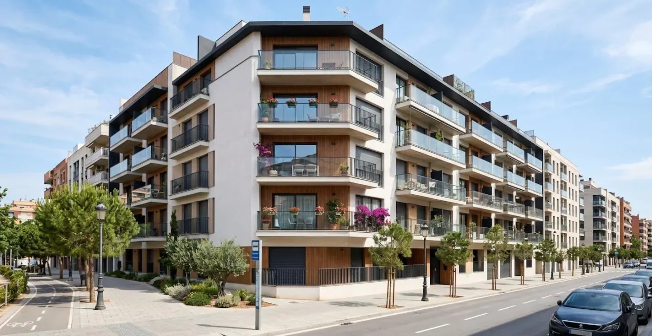 Vista angular amplia de fachada de edificio residencial moderno con balcones y arquitectura contemporánea en entorno urbano español con luz natural diurna